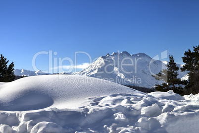 Snowdrifts in winter mountain after snowfall at sun day