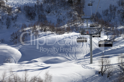 Chair-lift and off-piste slope in winter day
