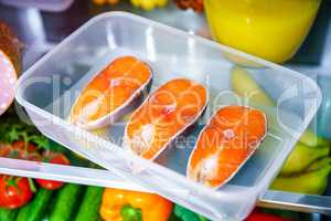 Raw Salmon steak in the open refrigerator