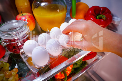 Chicken eggs on a shelf open refrigerator