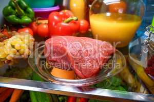 Fresh raw meat on a shelf open refrigerator