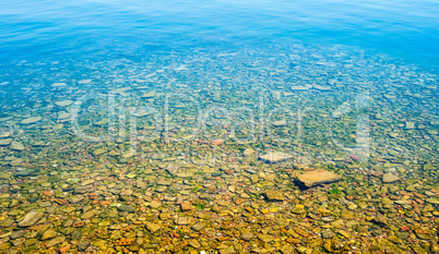 Transparent shallow water with rocky bottom.