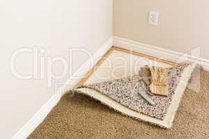 Gloves and Utility Knife On Pulled Back Carpet and Pad In Room.