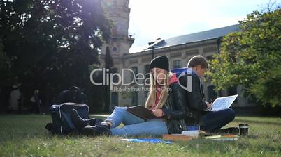 Young student couple studying in the park lawn