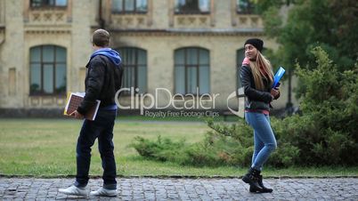Smiling girl flirting with young guy at the street