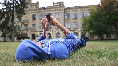 Young male student browsing on smart phone