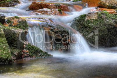 Long exposure of the water flowing over boulders