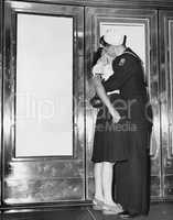 U.S. sailor and his girlfriend celebrate news of the end of war with Japan in front of the Trans-Lux Theatre in New York's Time Square, August 14, 1945