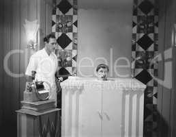 Man in steam bath with assistant and dictaphone