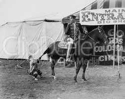 Circus performer pulling horses tail