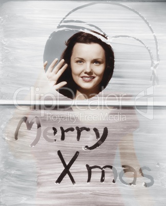 Woman waving at window with Christmas greeting