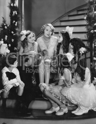 Woman singing with children on staircase at Christmas
