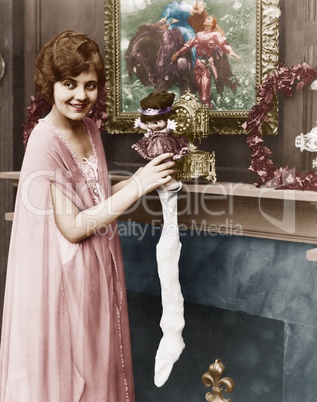 Smiling woman stuffing Christmas stocking