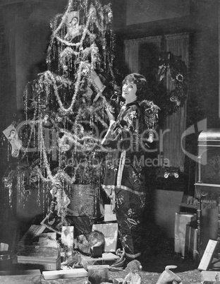 Teenage girl decorating Christmas tree