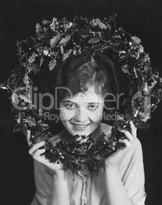 Portrait of woman holding Christmas wreath
