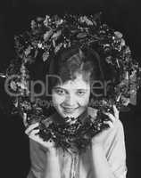 Portrait of woman holding Christmas wreath