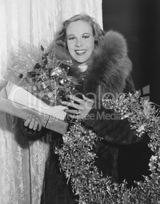 Portrait of woman with Christmas wreath and gifts