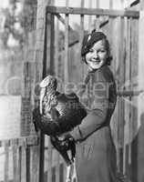 Smiling woman holding live turkey