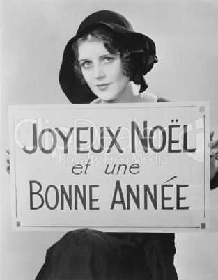Portrait of woman holding sign written in French