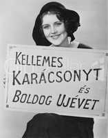 Portrait of woman holding sign written in foreign language