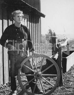 Portrait of craftsman with wooden wheel