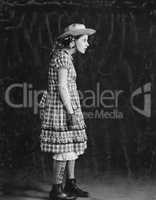 Portrait of girl in plaid dress and straw hat