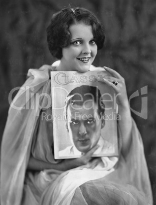 Woman with portrait of man on magazine cover