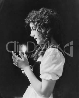 Portrait of woman holding lit candle