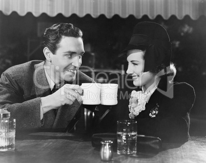 Couple toasting with mugs
