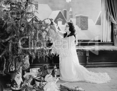 Teenage girl decorating Christmas tree