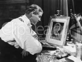 Man looking at portrait of woman