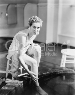 Portrait of woman soaking feet in footbath