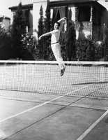 Male tennis player jumping for shot