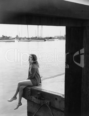Portrait of woman sitting on dock