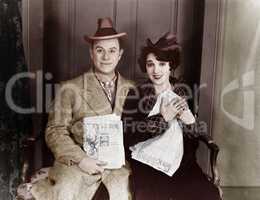Portrait of smiling couple with newspapers