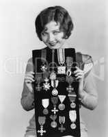 Woman holding display of medals