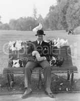 Man feeding pigeons on park bench