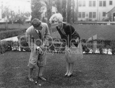 Man talking to woman while golfing