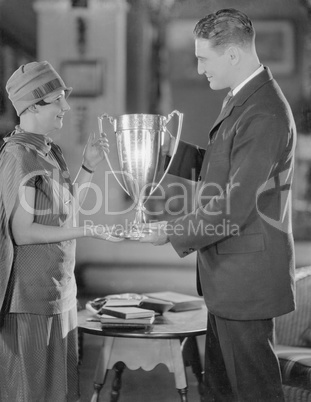 Man and teenage girl with trophy