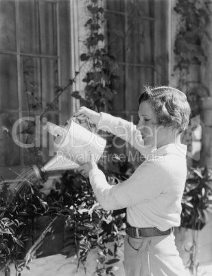 Woman watering plants in window boxes