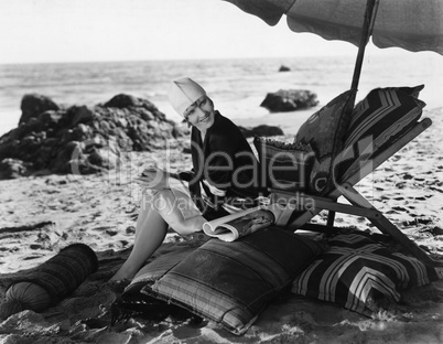 Woman relaxing under umbrella on beach