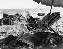 Woman relaxing under umbrella on beach