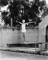 Woman on diving board at swimming pool