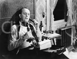 Man with typewriter talking on phone