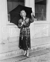 Woman with umbrella testing for rain