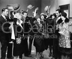 Group of people taking hats off to woman