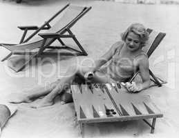 Woman playing backgammon on beach