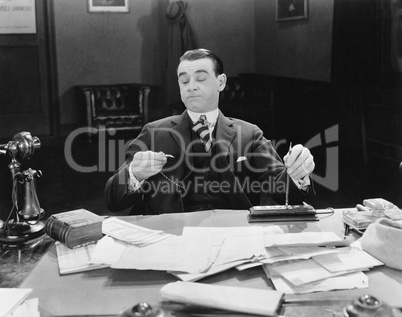 Businessman at desk looking at watch