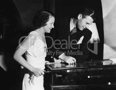 Couple playing with pinball machine