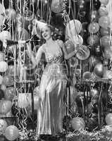 Woman celebrating with room full of balloons